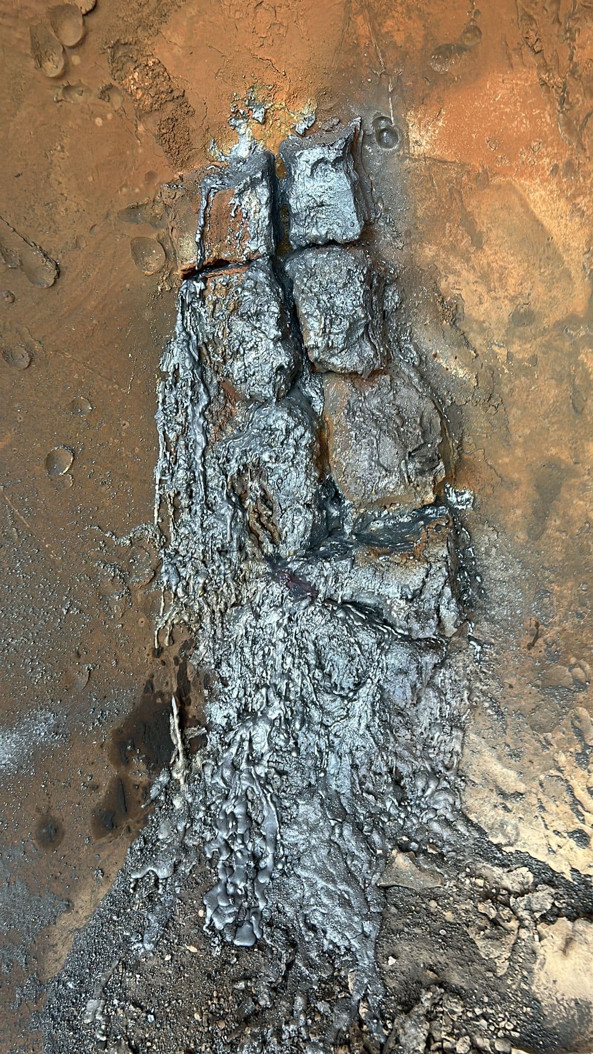 Solidified slag deposits inside industrial vessel close-up
