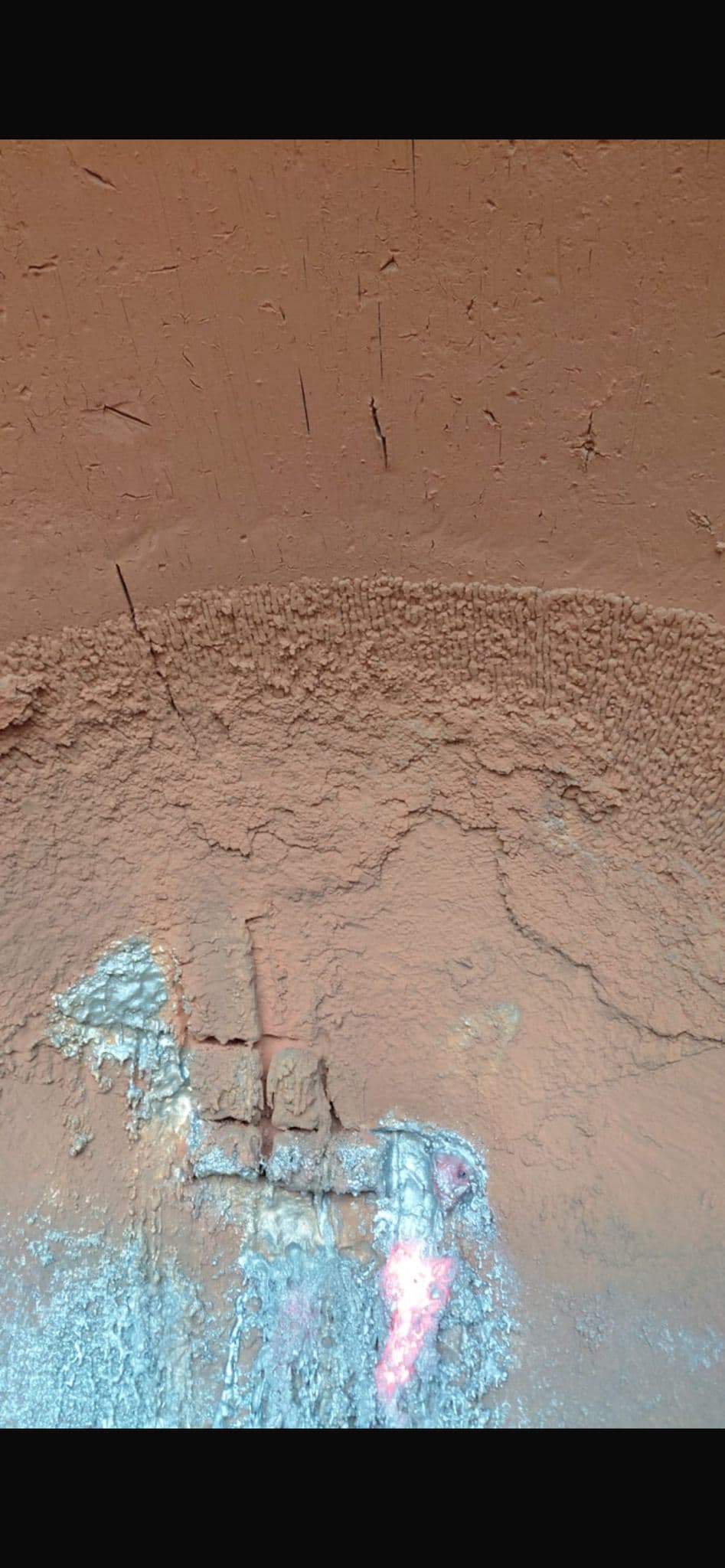 Cracked refractory lining with arc gouging marks in slag pot
